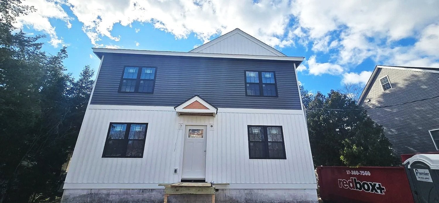 Two-story home with new two-tone vertical and lap siding